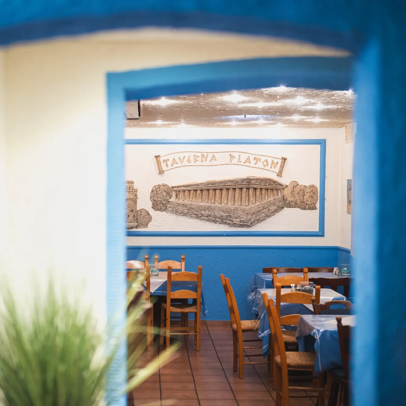 Innenraum der Taverna Platon mit blau-weißer Einrichtung und warmem Licht